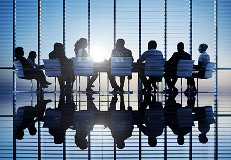 Silhouette of people sitting around a table